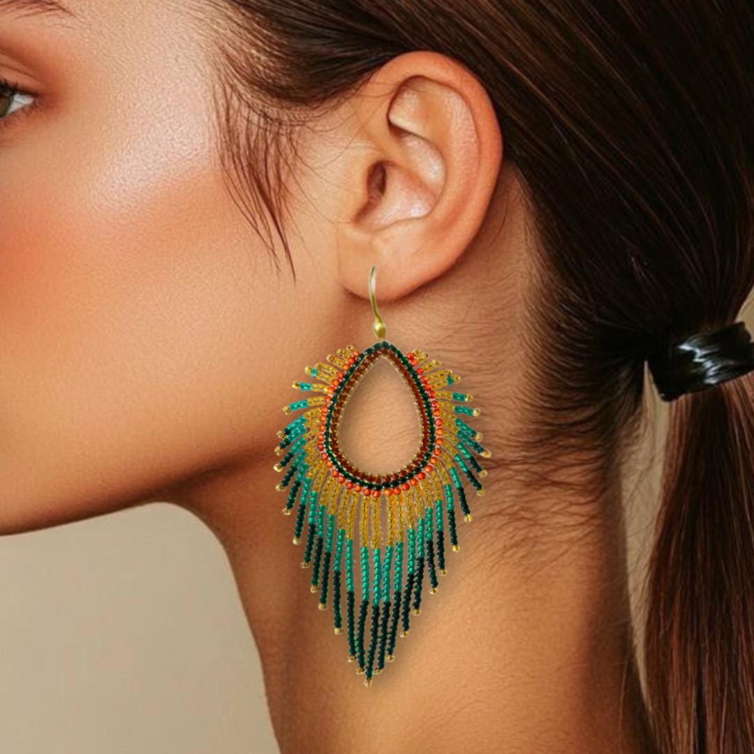 A teardrop-shaped earring with a gold hook. The earring features a beaded design with a gradient of colors. The top section is gold, transitioning to teal, then yellow, and finally black at the bottom, creating a fringe effect.