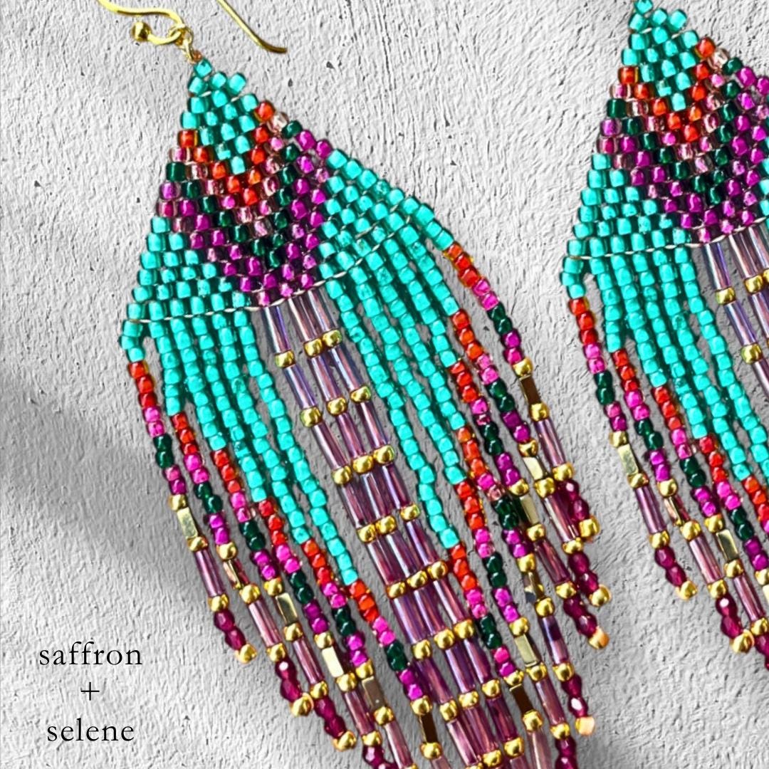 Close up of turquoise beadwork showing intricate detail of these handbeaded turquoise, purple and hot pink earrings with metalic gold detail.  Handmade by Saffron and Selene boho Jewelry for women