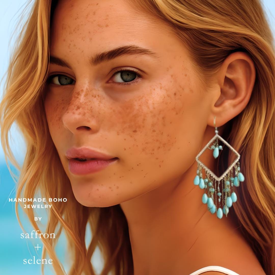 A close-up of a person wearing a silver earring with a diamond-shaped frame and turquoise beads. The earring hangs from a gold hook. The image has the text "saffron + selene" in the bottom left corner.