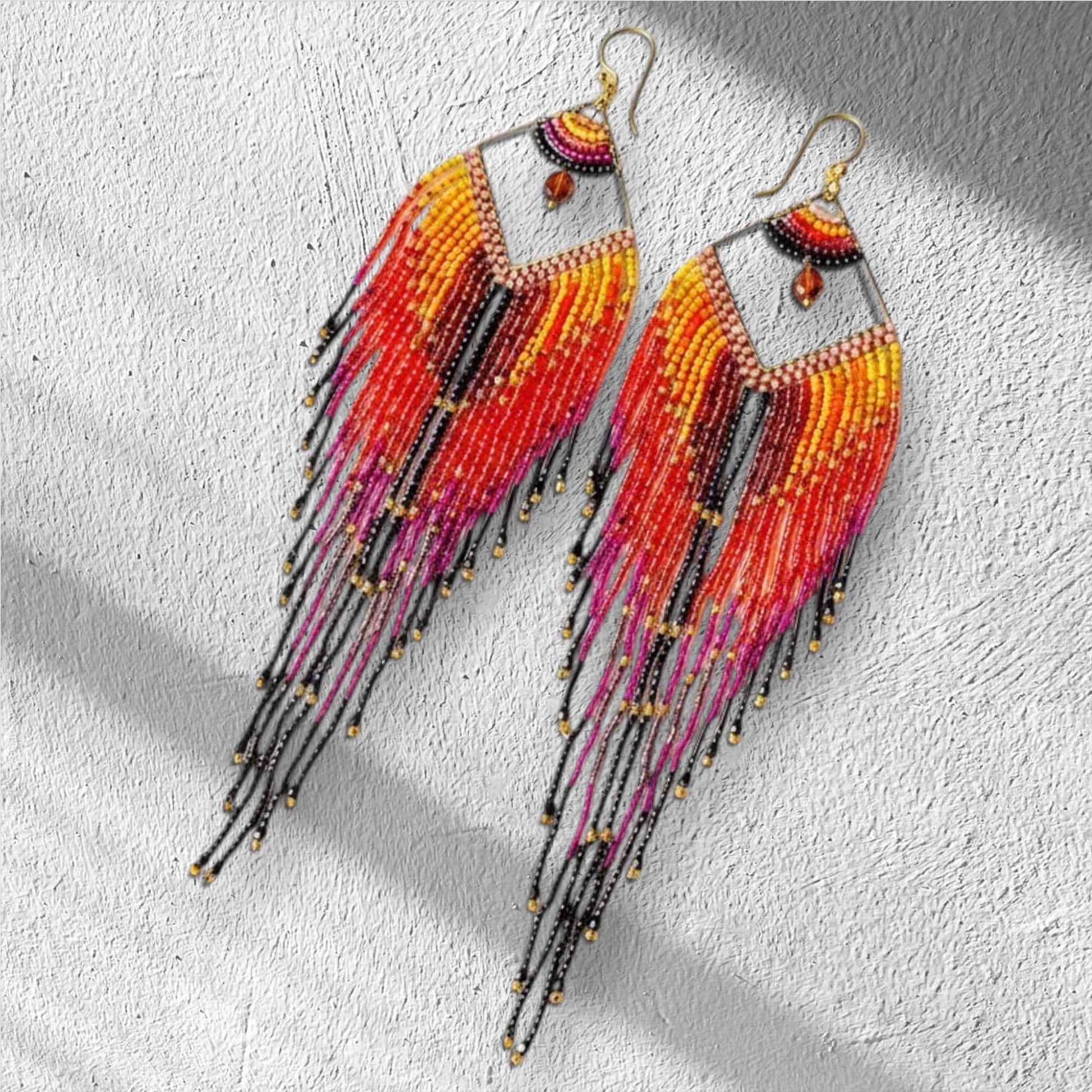 Artisan beadwork earrings featuring long fringe movement and gold accents