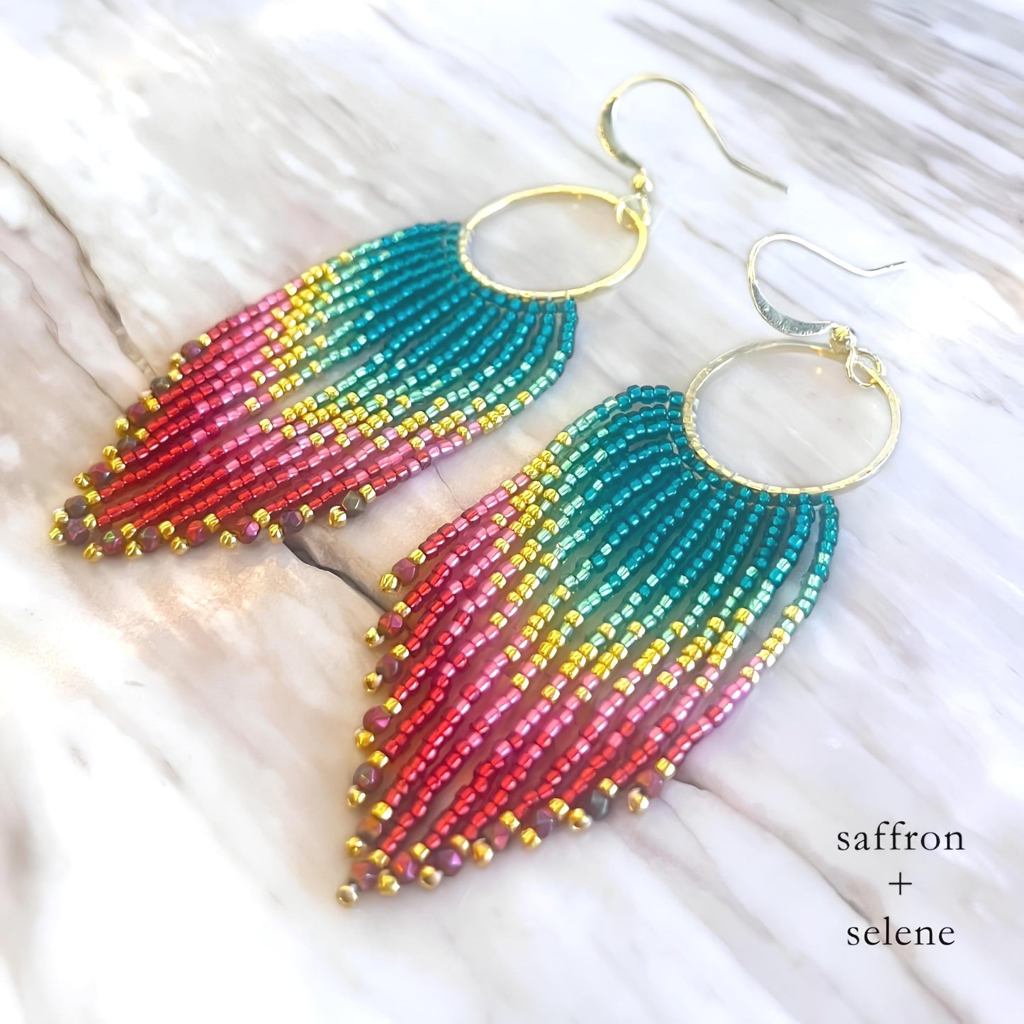 Handmade fringe earrings in a brightly coloured ombre aztec design.  Pink, yellow and turquise with metalic gold highlights.  Hand beaded by Meg at Saffron and Selene Boho Jewelry for Women