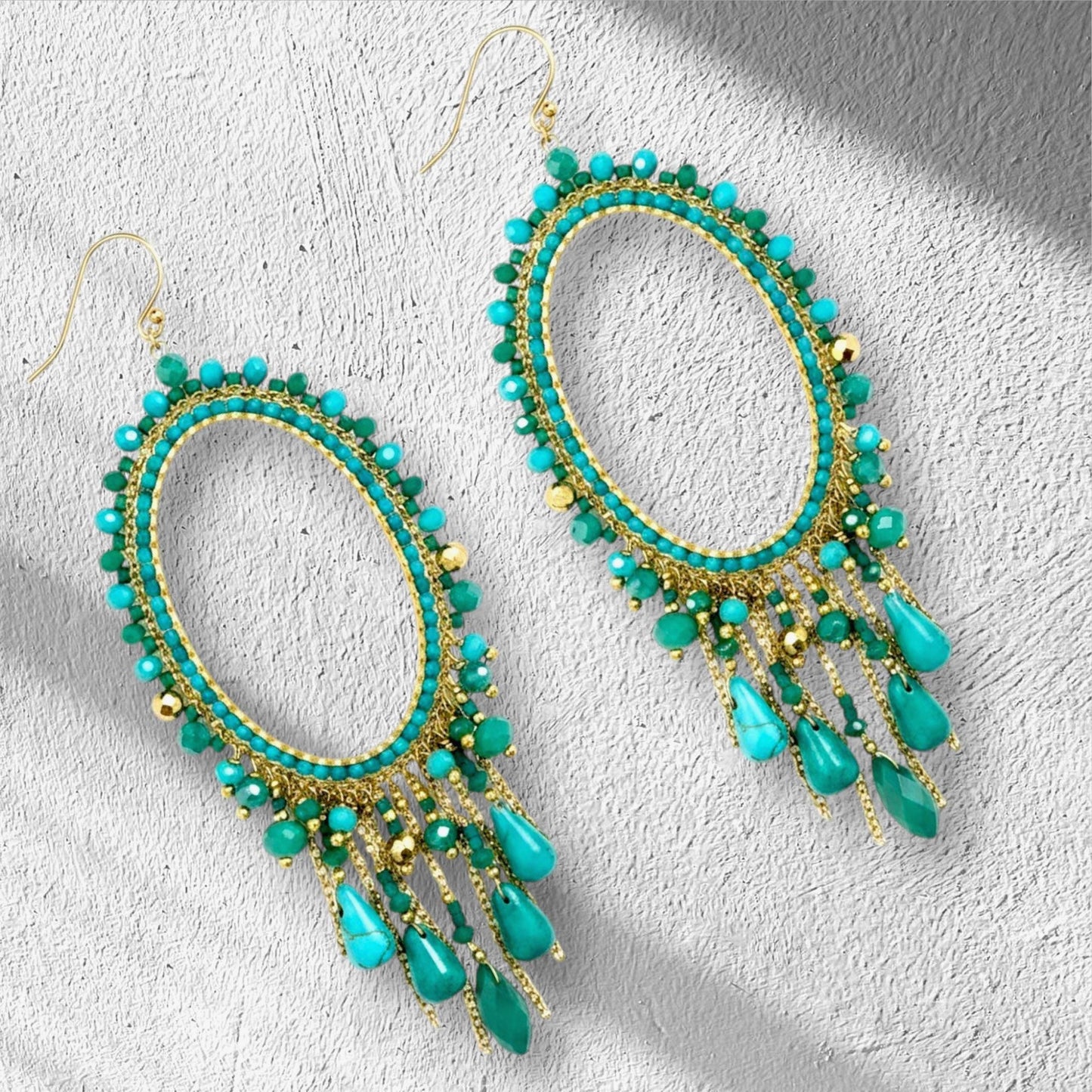 Handmade turquoise chandelier earrings with jade beads on gold oval hoop frame.