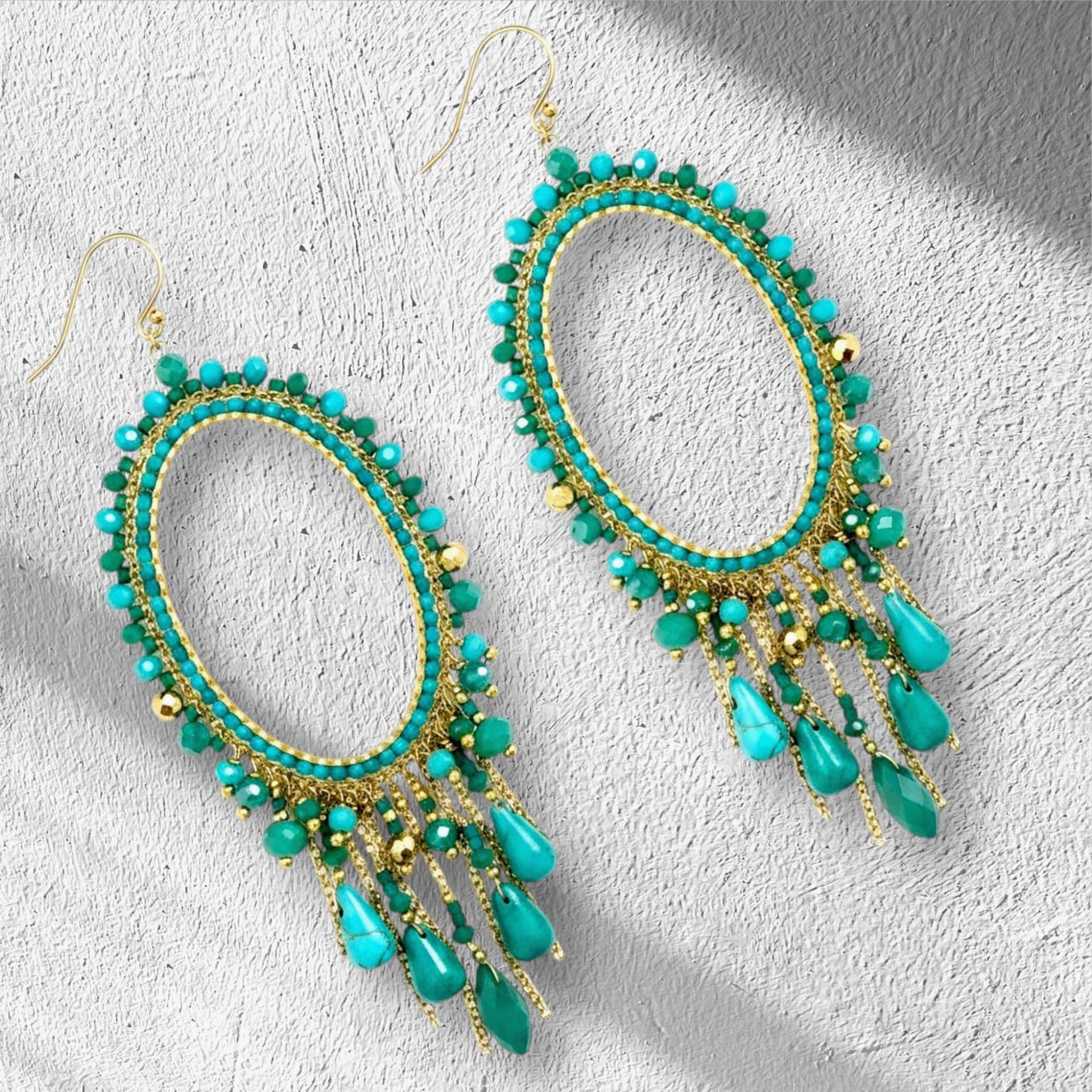 Handmade turquoise chandelier earrings with jade beads on gold oval hoop frame.