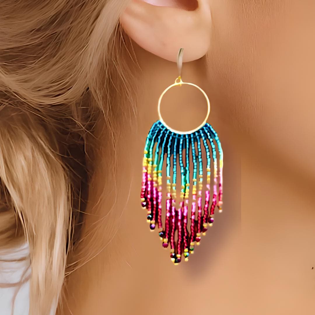 Handmade multi coloured fringe earrings.  Ombre rainbow coloured hand beaded tassels with metalic gold highlights, hanging from a 9kt gold plated circular hoop.  Hand threaded by Saffron and Selene Boho Jewelry for Women