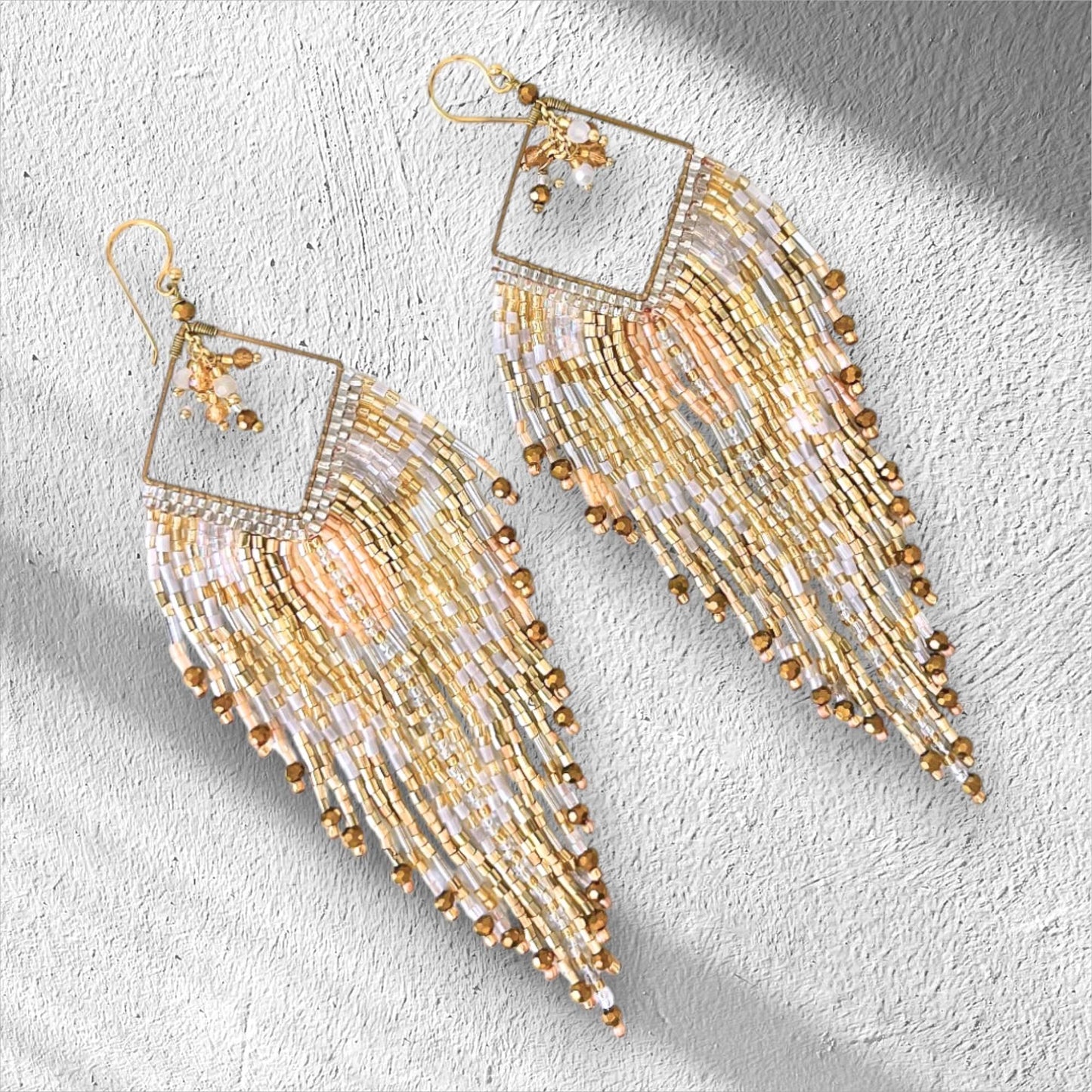 Champagne gold handmade fringe earrings with ivory beadwork and metallic gold details.