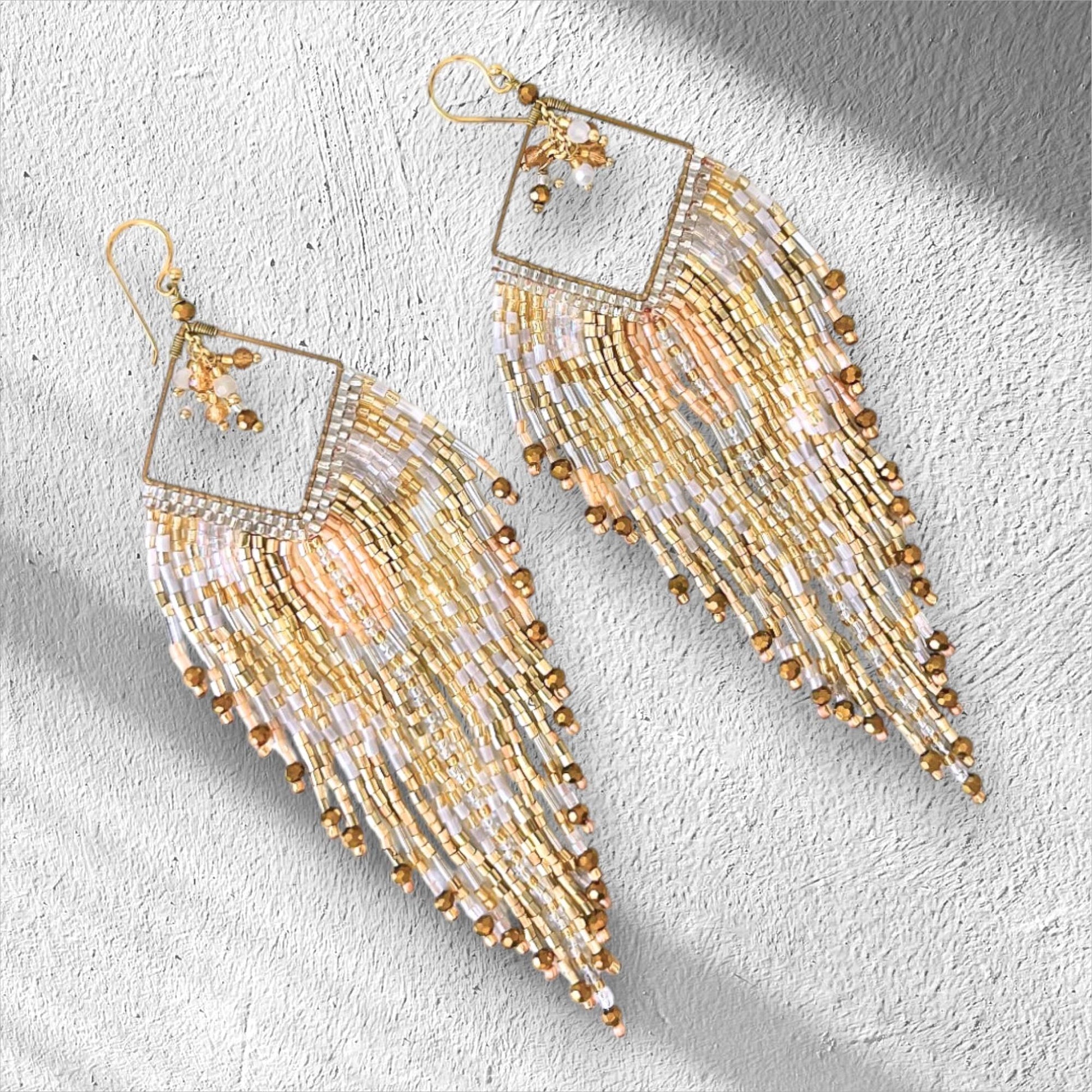Champagne gold handmade fringe earrings with ivory beadwork and metallic gold details.