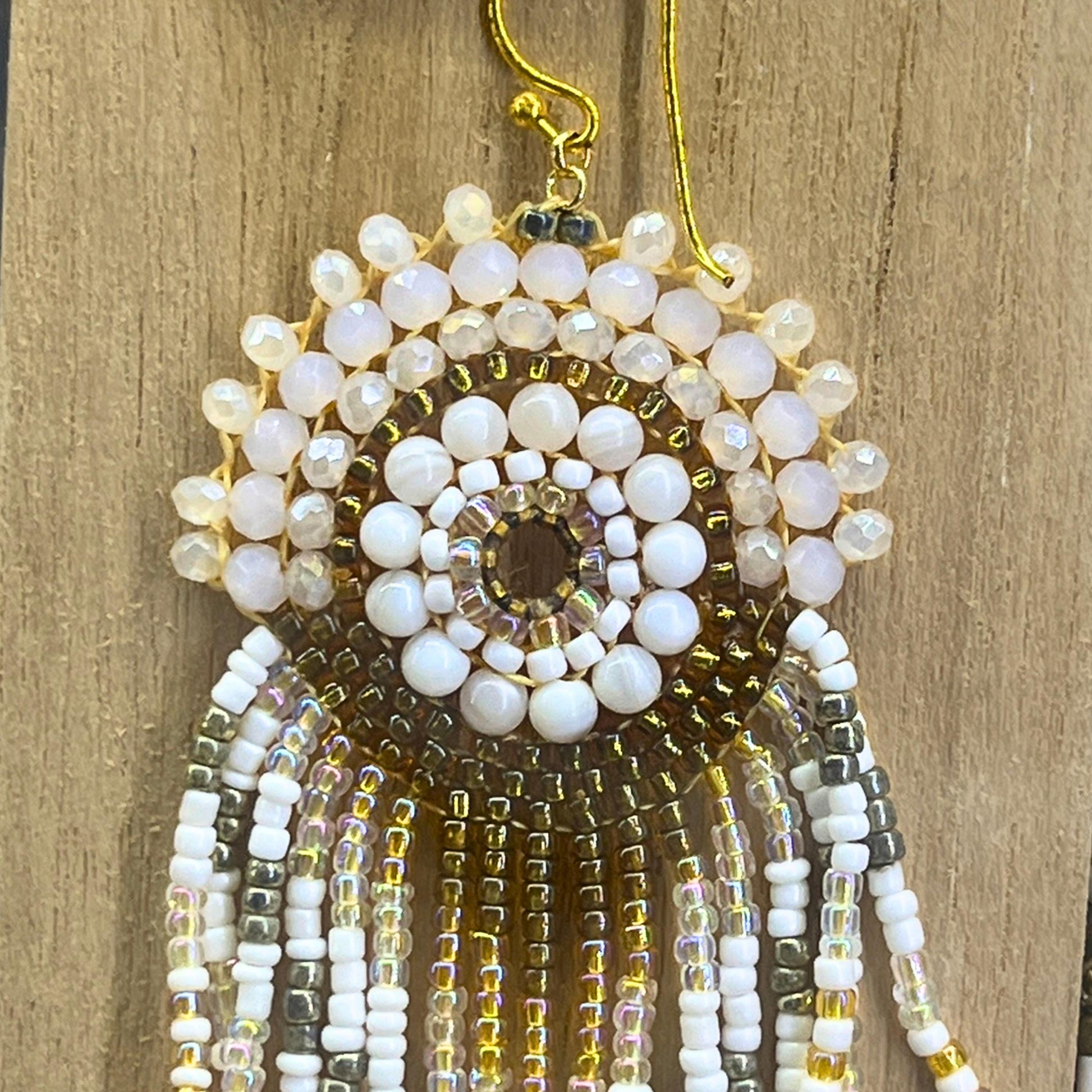 Close up of handmade ivory hand beaded fringe earrings by Saffron and Selene boho jewelry for women