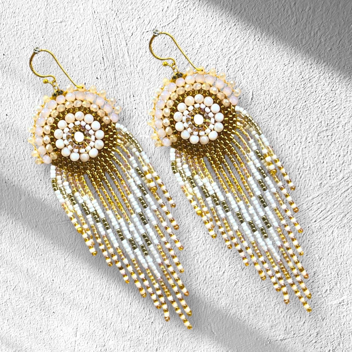 Luxury handmade ivory fringe statement earrings with champagne crystals, gold beadwork and long beaded tassels, individually handcrafted by designer Meg Wylde.
