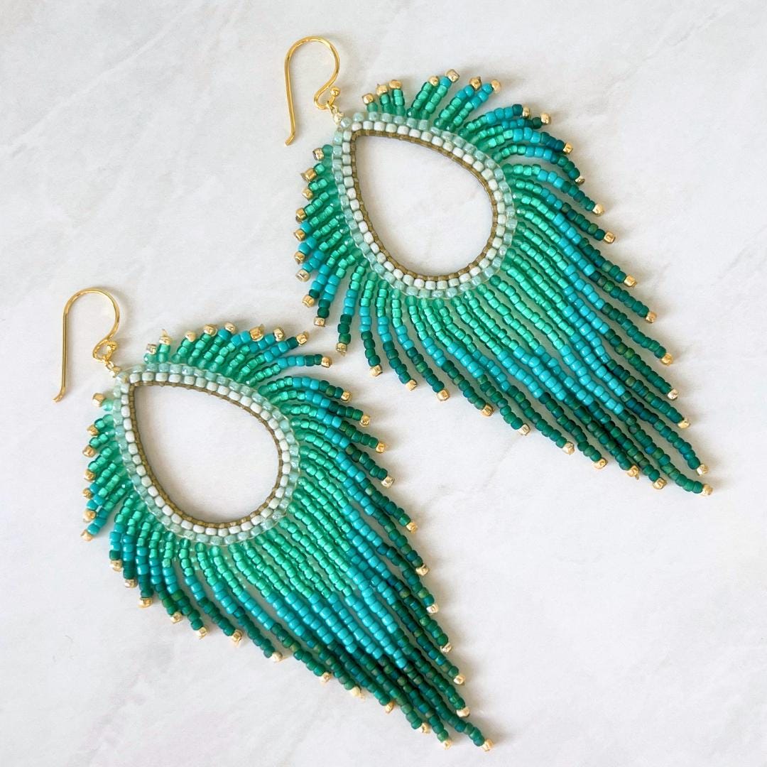 Handmade turquoise fringe earrings with ombre green glass seed beads and gold accents.