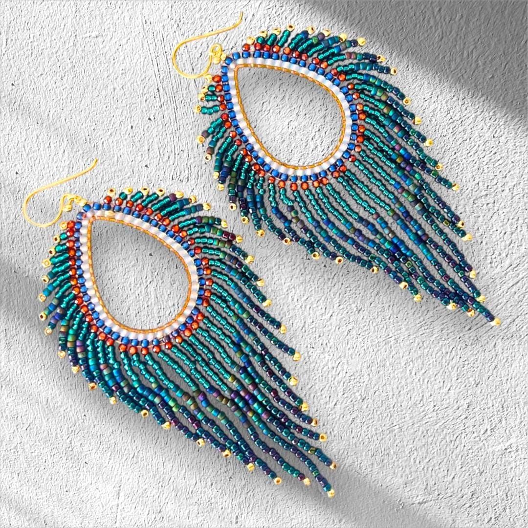 Handmade teal blue fringe earrings with shimmering metallic and iridescent glass beads.