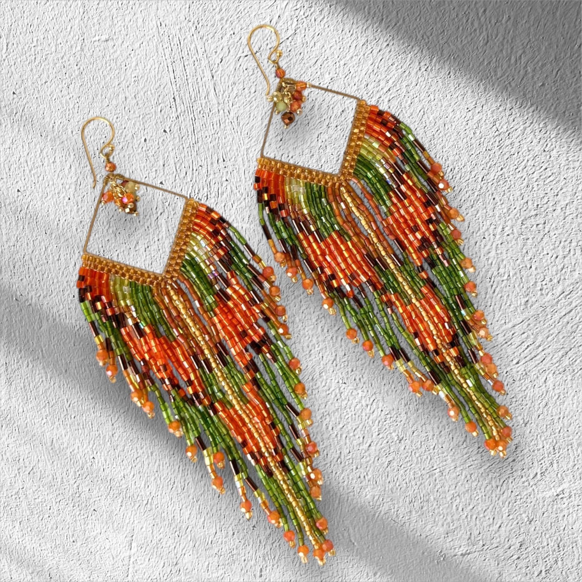 Handmade burnt orange fringe earrings with olive green Miyuki seed beads, gold frame and long boho statement design.